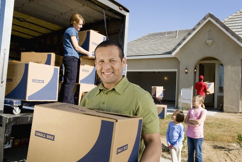 Mover carrying boxed items carefully in a hallway